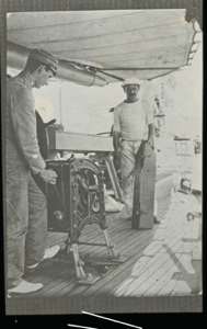 Image of Two men with equipment on deck. 